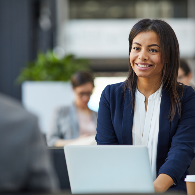 Happy, confident, young woman in a jacket, sitting while holding a meeting in a courtyard.