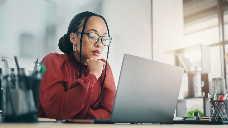 A government affairs professional evaluates AI tools on a laptop in a modern office