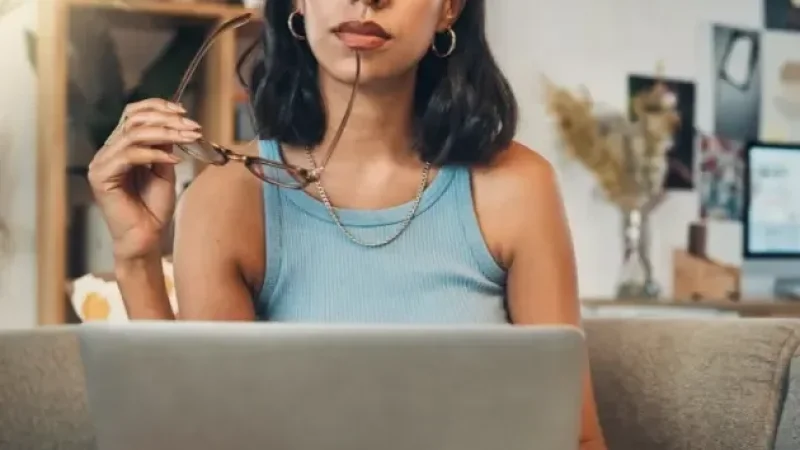 Woman thinking on laptop